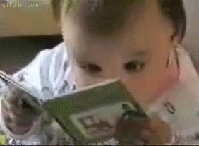 Baby reading book intensely