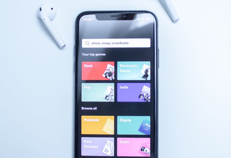 Spotify on a smartphone with some earbuds